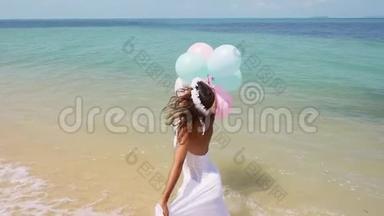 欢乐的女孩在海滩上奔跑，手里拿着气球。 慢动作。 概念幸福、自由